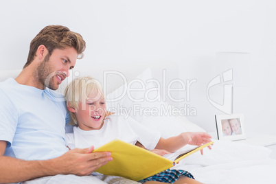 Portrait of a smiling father reading a story to his son