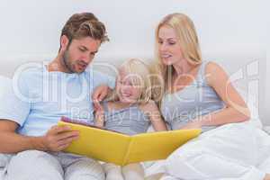 Couple reading a story to daughter