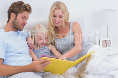 Beautiful couple reading a story to daughter