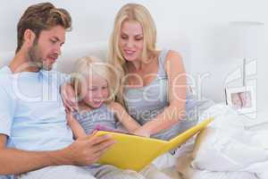 Beautiful couple reading a story to daughter