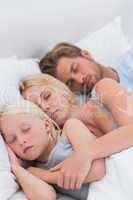 Couple sleeping with daughter