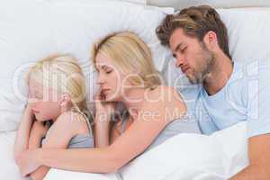 Beautiful couple sleeping with daughter