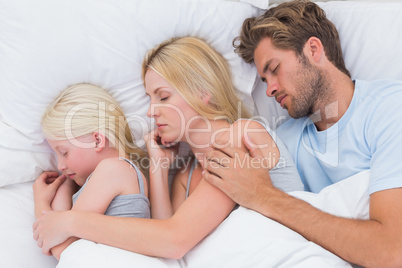 Couple sleeping with cute daughter