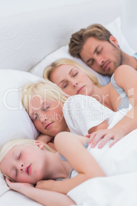 Couple sleeping with their children