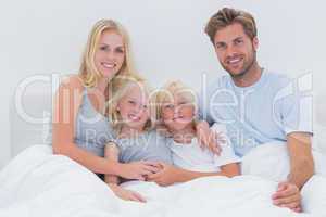 Portrait of a cheerful family in bed