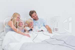 Siblings playing video games with parents watching