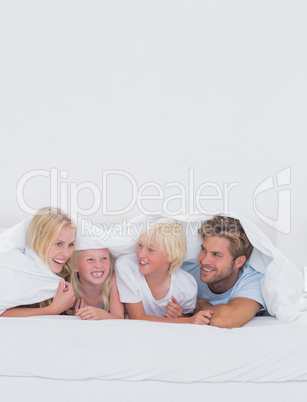 Cheerful family under the duvet