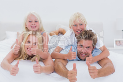 Parents giving piggy back to their children while giving thumbs