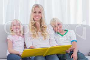 Portrait of a mother reading a story to children
