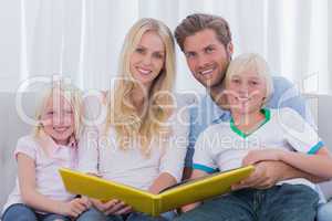 Portrait of a family holding a story book