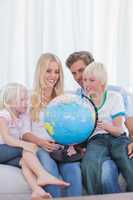 Happy family looking at globe on couch