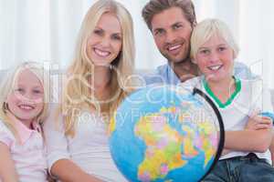 Family sitting on couch holding globe