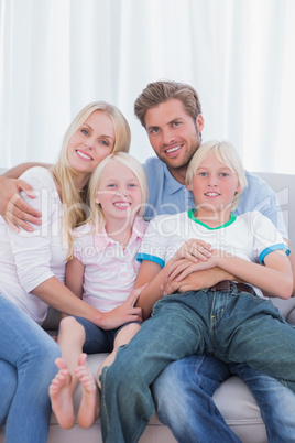 Parents and children sitting together on couch