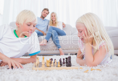 Cute siblings playing chess