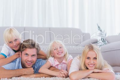 Smiling family lying on the carpet Smiling family lying on the carpet