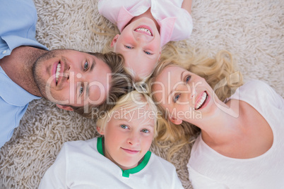Overhead of family lying on the carpet