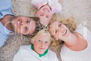 Overhead of family lying on the carpet