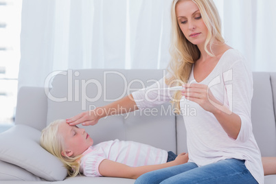 Mother measuring the temperature of her daughter