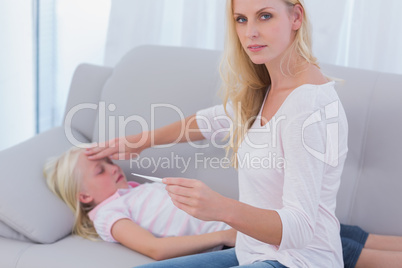 Mother taking her daughter's temperature