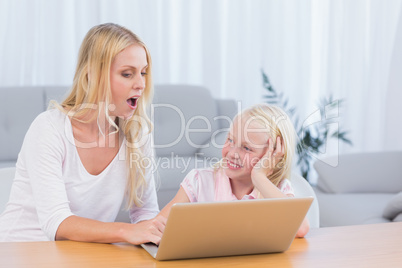 Mother and daughter using laptop