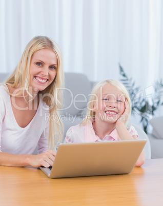 Mother and daughter using laptop in the living room