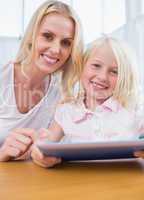 Mother using tablet pc with her daughter