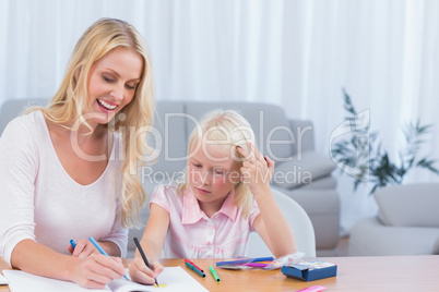 Smiling mother and daughter drawing