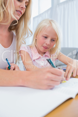 Mother and daughter drawing at the table
