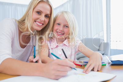 Mother and daughter drawing together in the living room