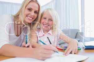Mother and daughter drawing together in the living room