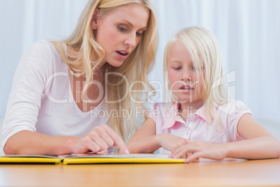 Mother and daughter reading a book together