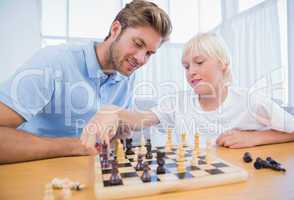 Boy playing chess with his father