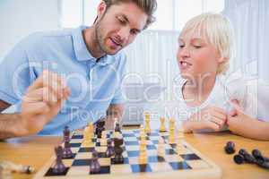 Father and his son playing chess together