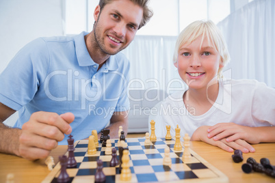 Father and his little boy playing chess