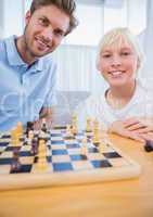 Father playing chess with his little boy