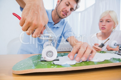 Father repairing a skateboard with his son