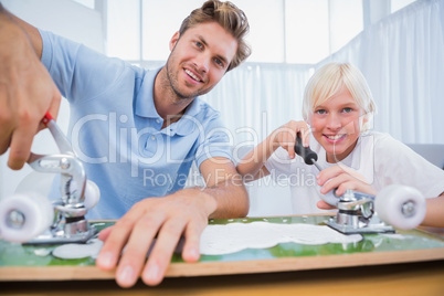 Father and son repairing a skateboard