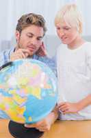 Father and his son looking at globe