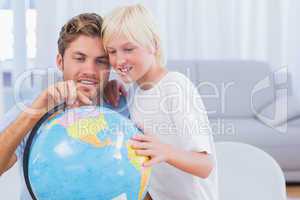 Father and his boy looking at globe