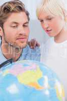 Father and son looking at globe together