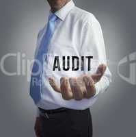 Businessman holding the word audit