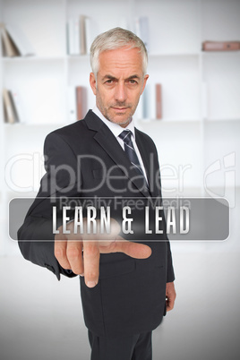 Serious businessman touching the term learn and lead
