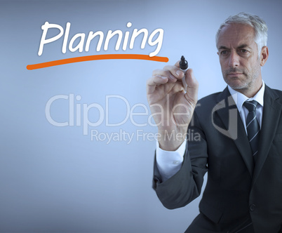 Businessman writing the word planning