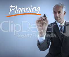 Businessman writing the word planning