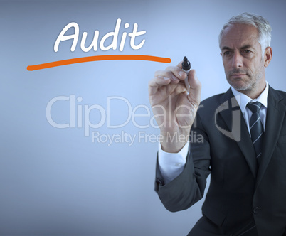 Businessman writing the word audit