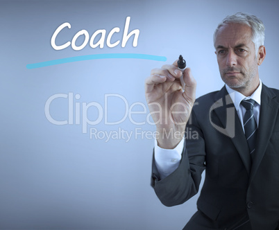 Businessman writing the word coach