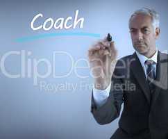 Businessman writing the word coach