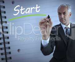 Businessman standing and writing the word start