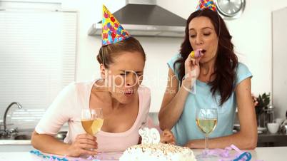 Women wearing party hats celebrating birthday together