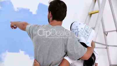 Young couple looking at painted wall